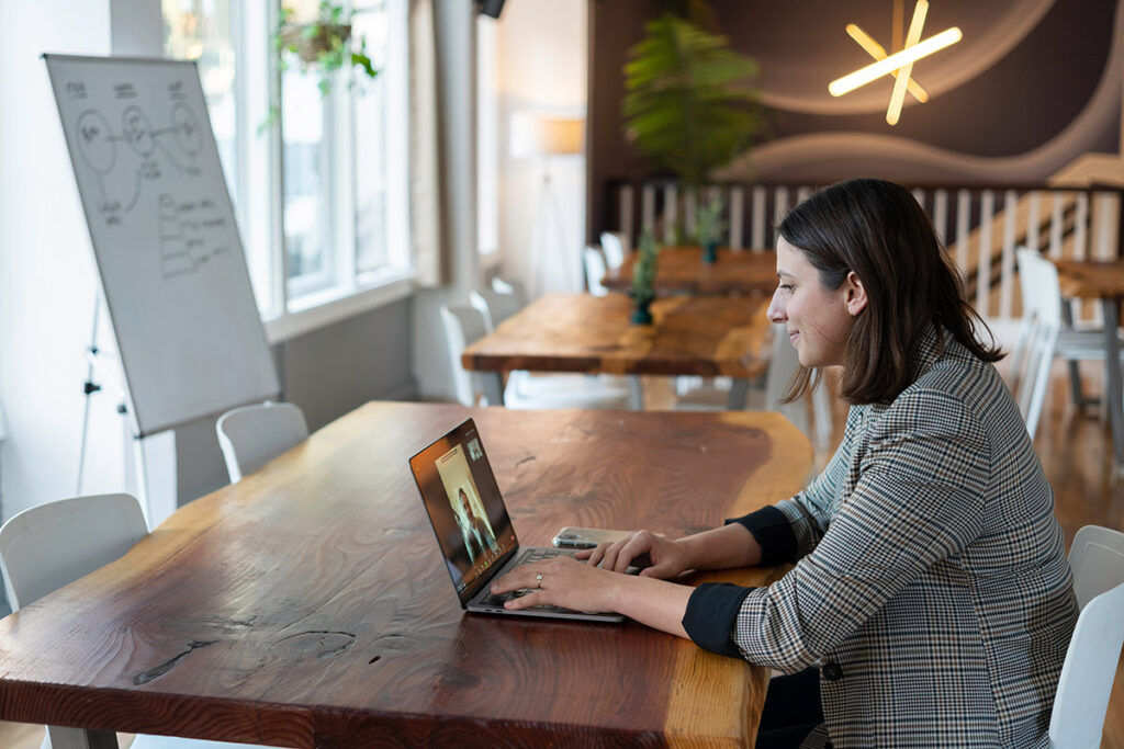 A woman in an office having a virtual meeting on her laptop
